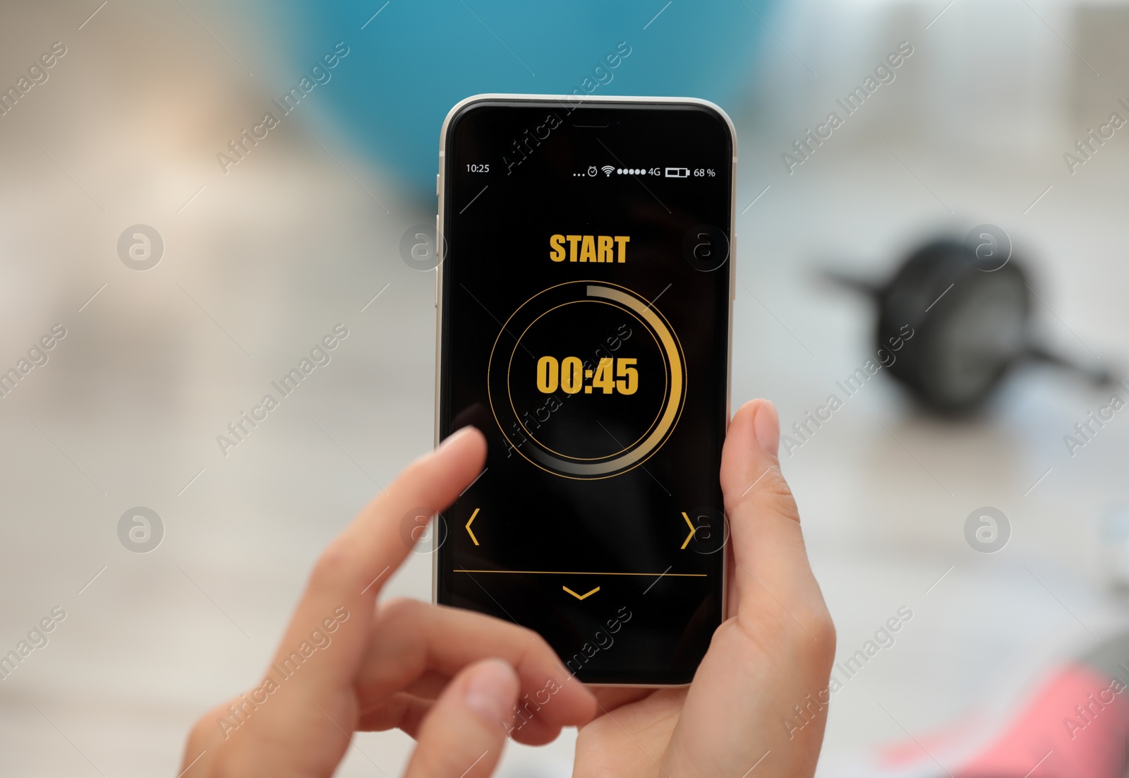 Photo of Young woman using fitness app on smartphone indoors, closeup