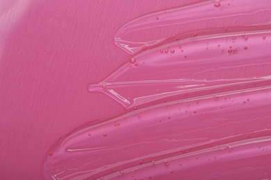 Photo of Pure transparent cosmetic gel on pink background, top view