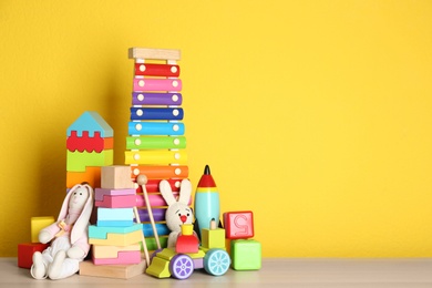 Photo of Set of different toys on wooden table. Space for text