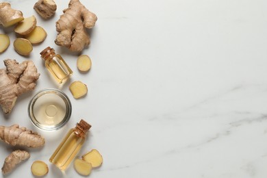 Glass bottles of essential oil and ginger root on white marble table, flat lay. Space for text