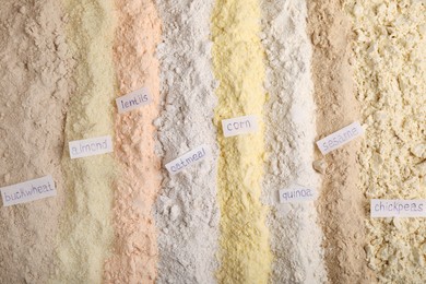 Different types of flours as background, top view