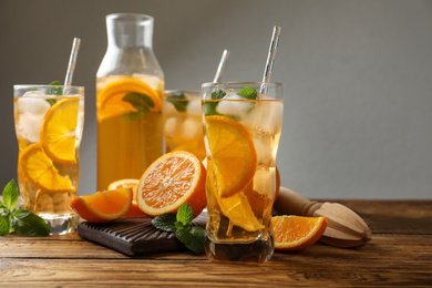 Photo of Delicious refreshing drink with orange slices on wooden table