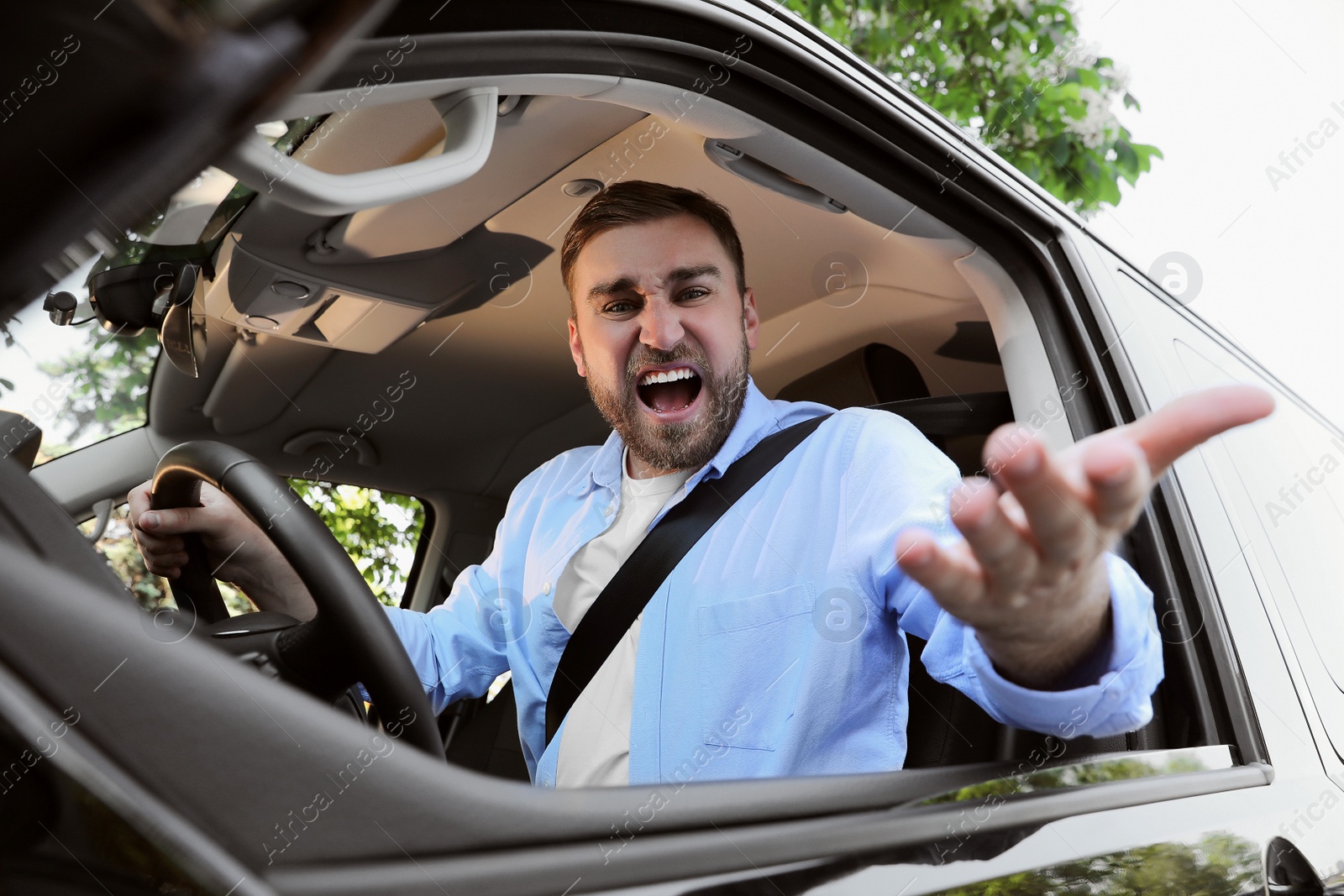 Photo of Emotional man in car. Aggressive driving behavior