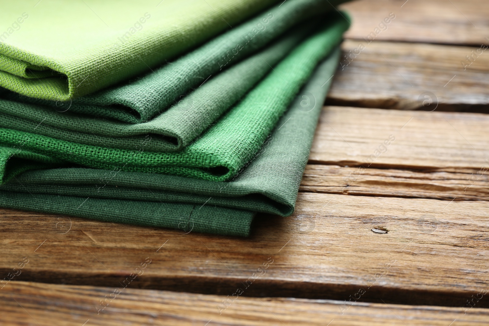 Photo of Different kitchen napkins on wooden table, closeup. Space for text