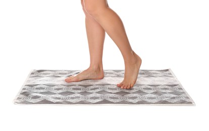 Woman standing on stylish bath mat against white background, closeup