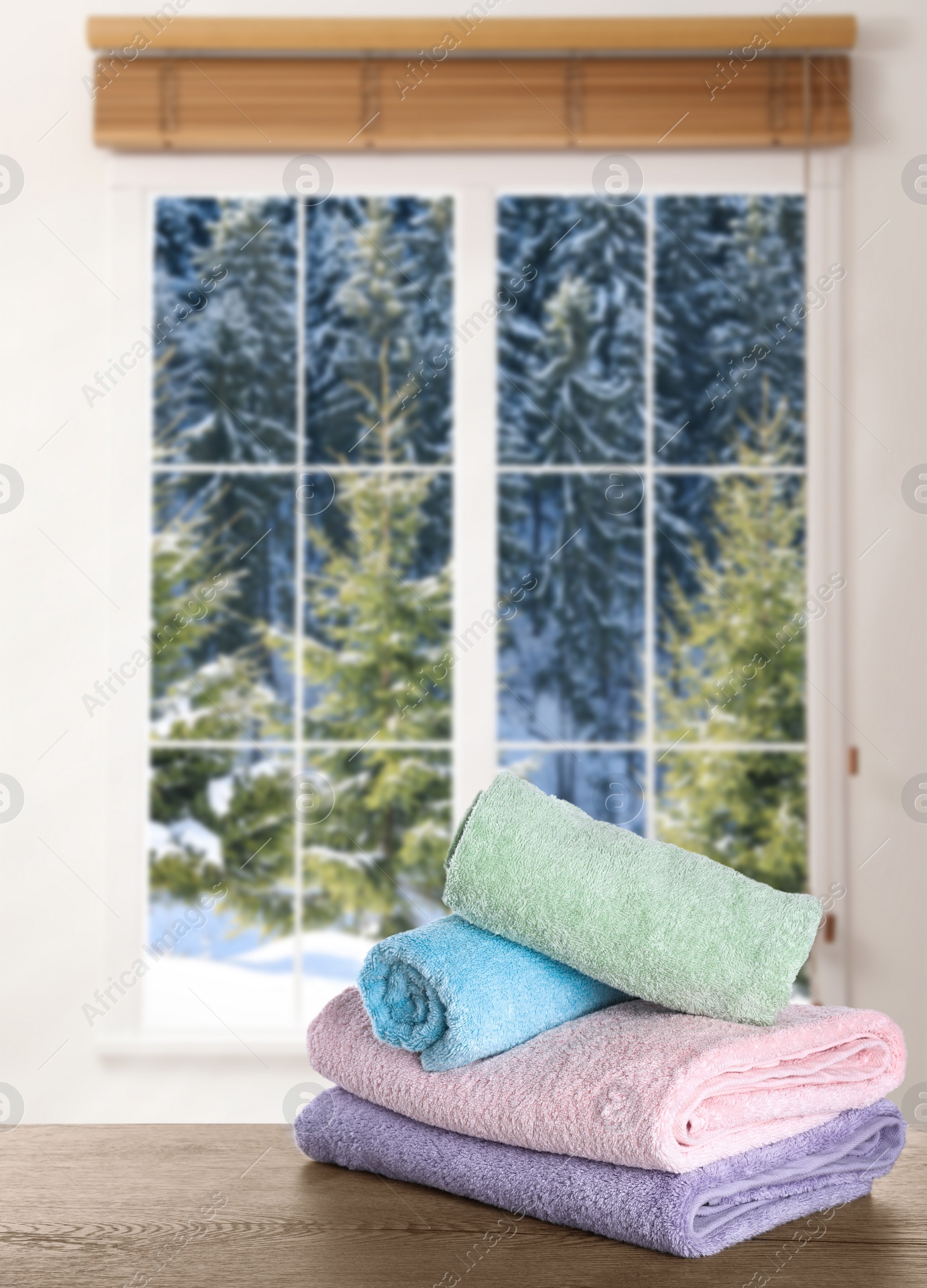 Image of Fresh towels on wooden table and window with beautiful view indoors