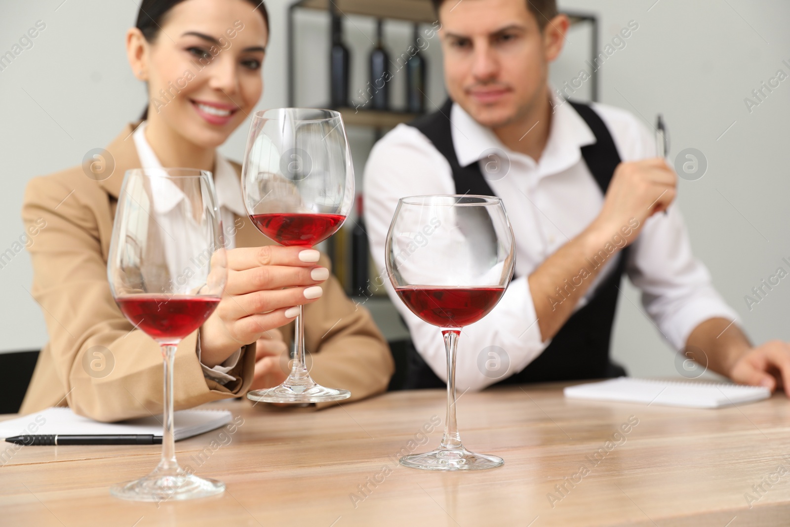 Photo of Sommeliers tasting different sorts of wine at table indoors