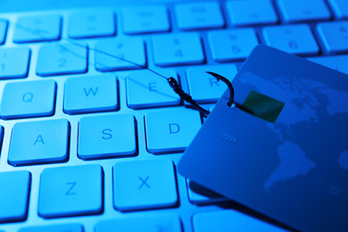 Photo of Fishing hook with credit card and computer keyboard, closeup. Cyber crime