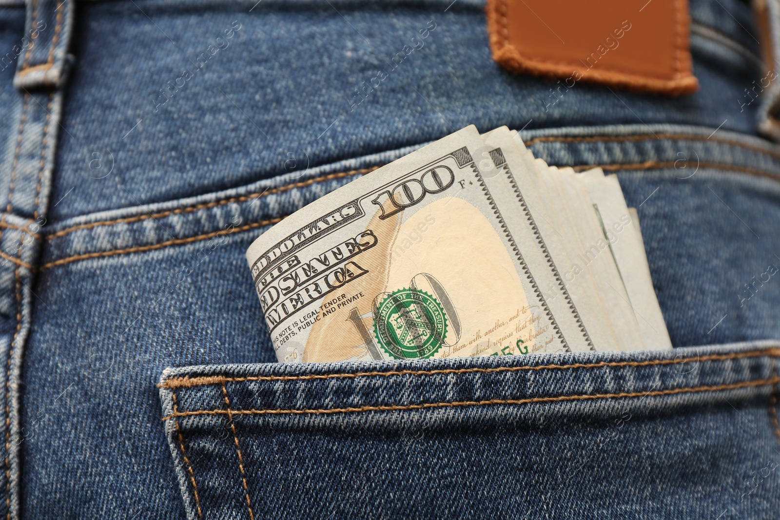 Photo of Dollar banknotes in pocket of jeans, closeup. Spending money