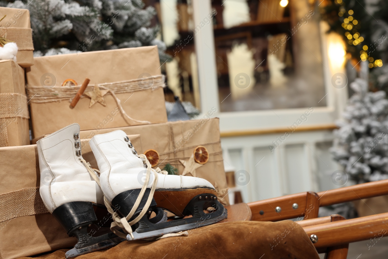 Photo of Many gift boxes, skates and festive decor indoors. Interior design