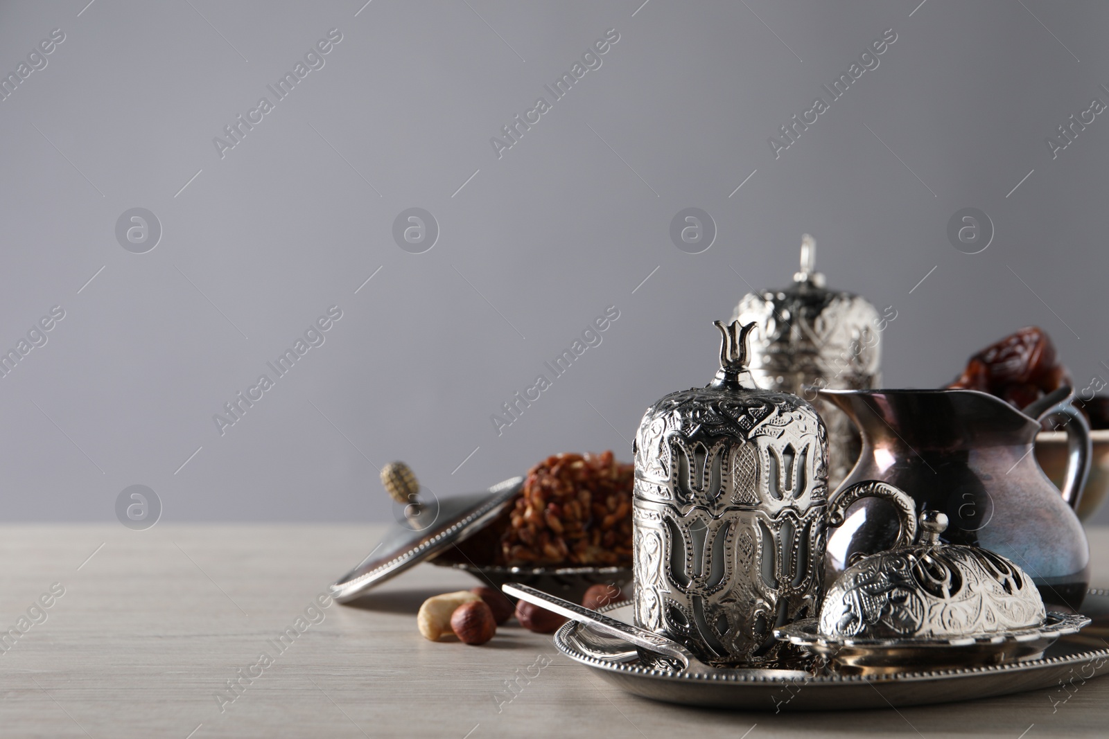 Photo of Tea, date fruits and Turkish delight served in vintage tea set on wooden table, space for text