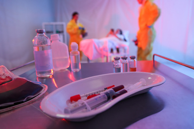 Medical bowl with samples of virus on table in quarantine ward