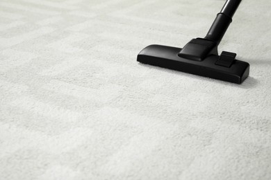 Removing dirt from white carpet with modern vacuum cleaner. Space for text