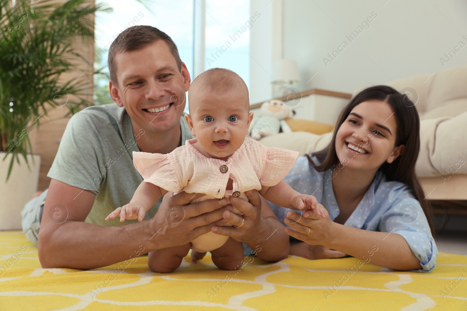 Photo of Happy family with their cute baby in living room at home