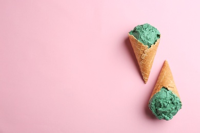 Photo of Delicious spirulina ice cream cones on color background, top view. Space for text