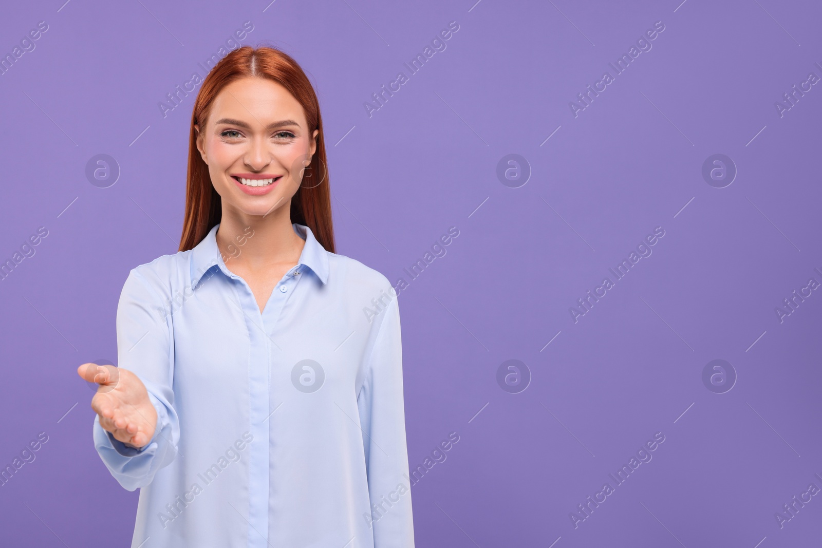 Photo of Happy woman welcoming and offering handshake on violet background, space for text