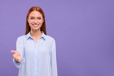 Photo of Happy woman welcoming and offering handshake on violet background, space for text
