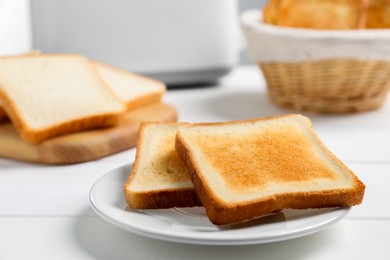 Photo of Slices of tasty toasted bread on white wooden table, closeup