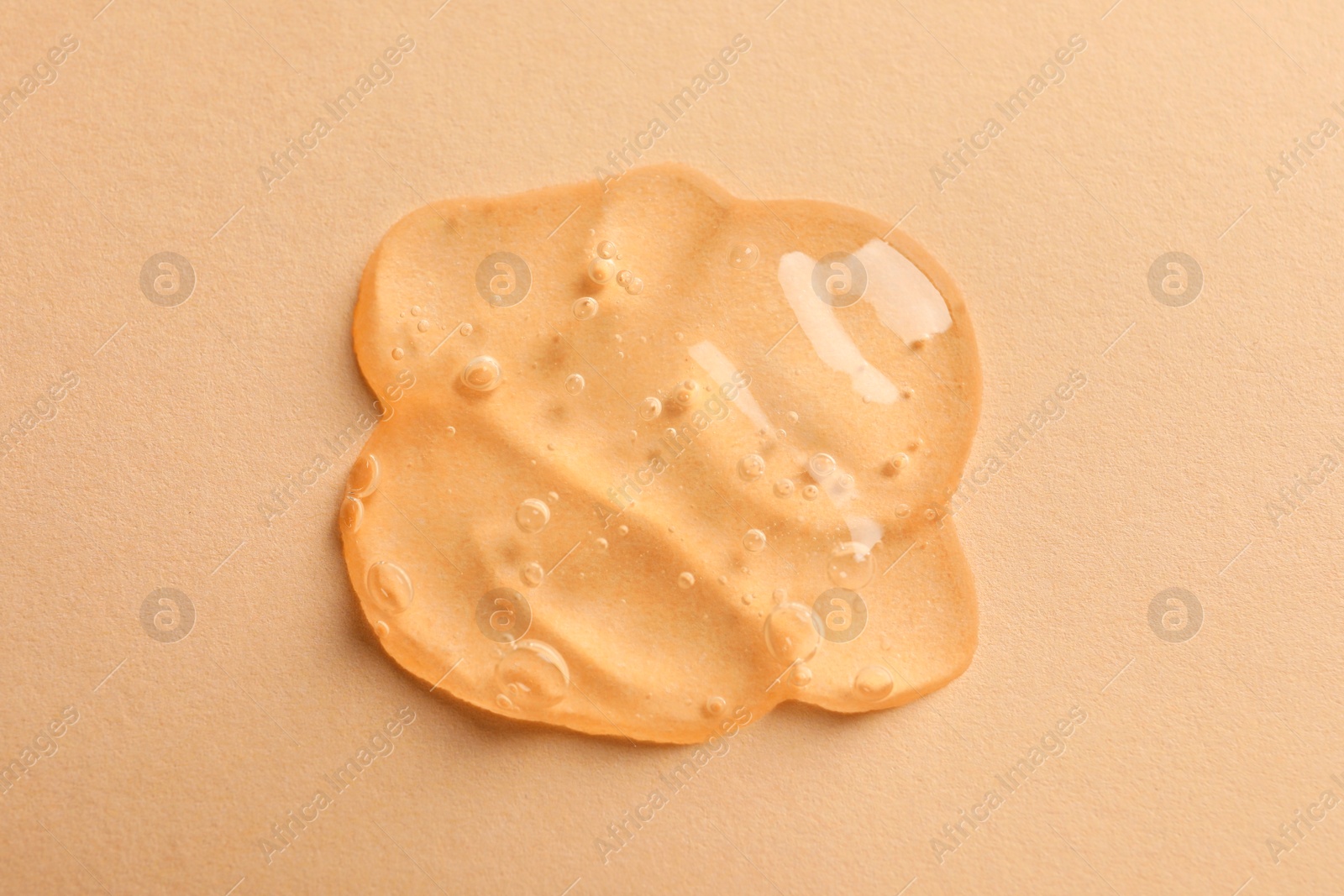 Photo of Sample of face gel on pale orange background, top view