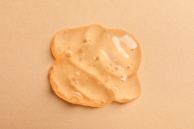 Photo of Sample of face gel on pale orange background, top view