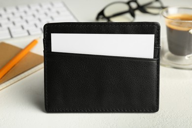 Photo of Leather business card holder with blank card on white table