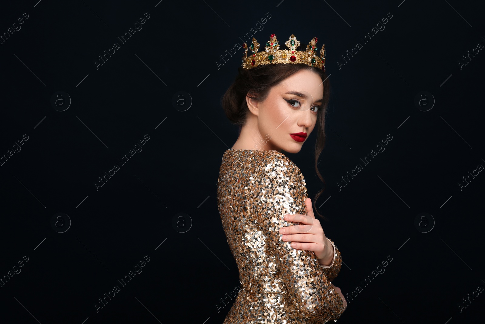 Photo of Beautiful young woman wearing luxurious crown on black background, space for text