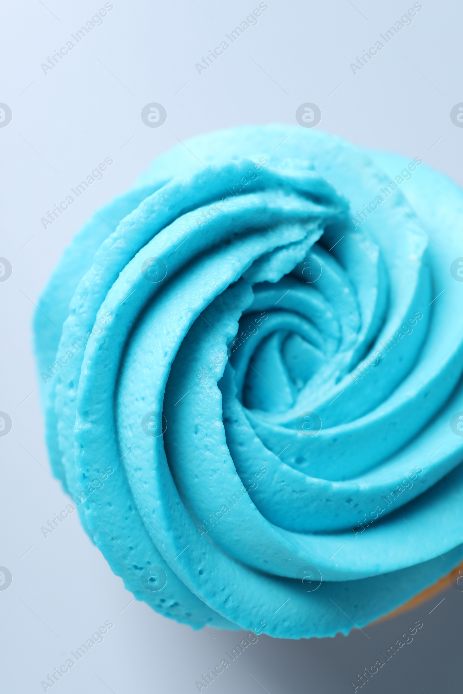 Photo of Delicious cupcake with bright cream on light background, top view