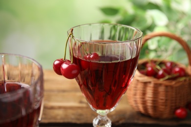 Photo of Delicious cherry wine with ripe juicy berries on table, closeup
