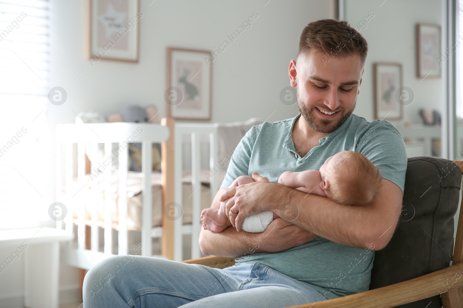 Photo of Father with his newborn son at home