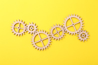 Photo of Business process organization and optimization. Scheme with wooden figures on yellow background, top view