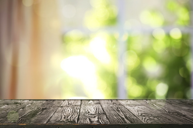 Image of Wooden table and blurred view through window on garden in morning. Springtime