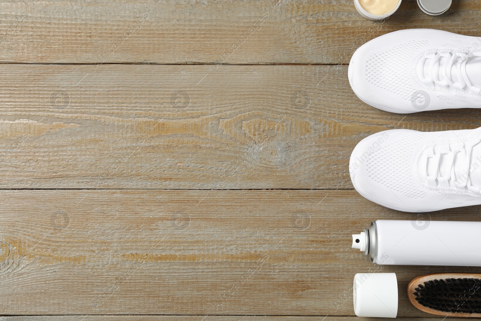 Photo of Flat lay composition with stylish footwear and shoe care accessories on wooden background, space for text