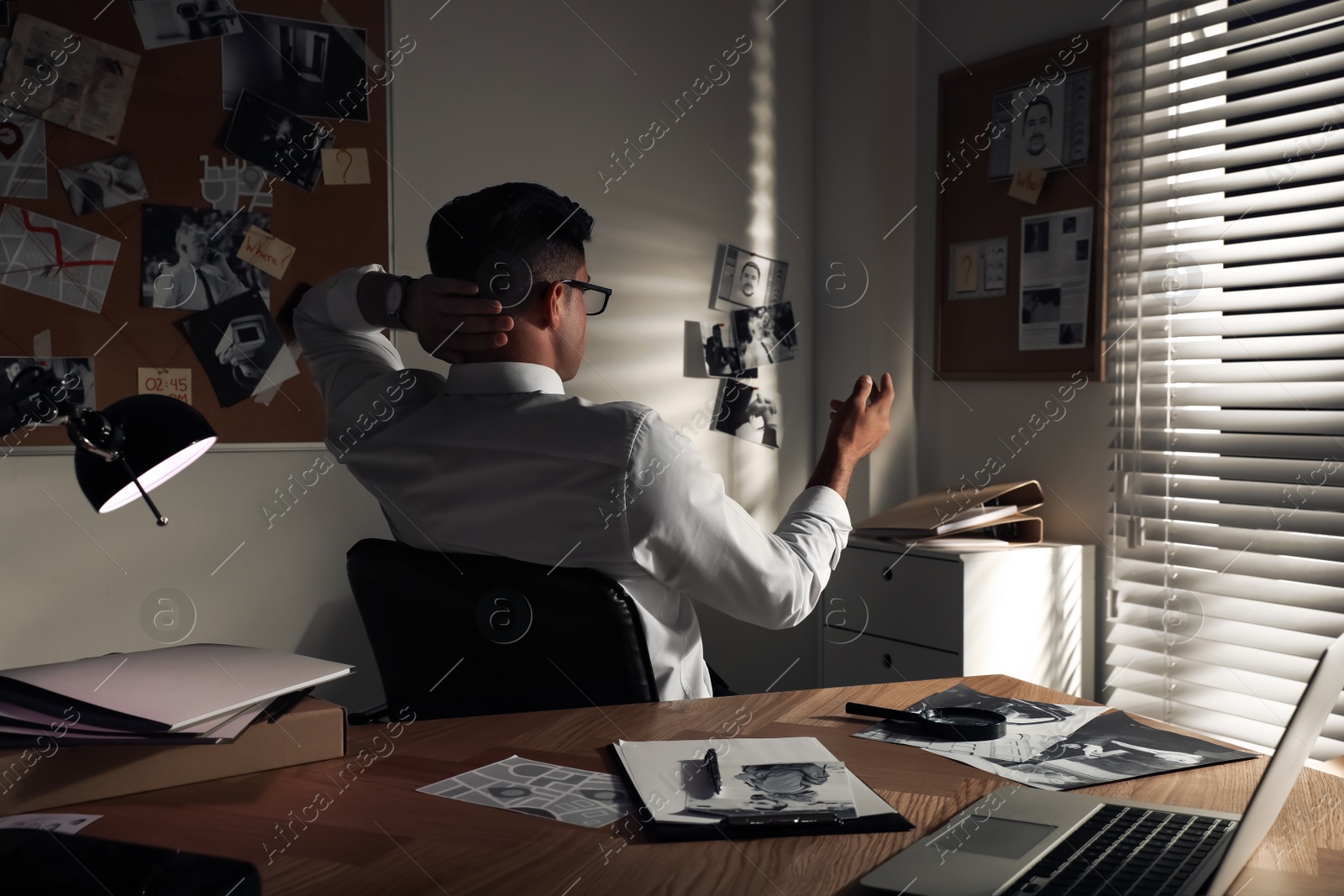 Photo of Detective looking at evidence board in office