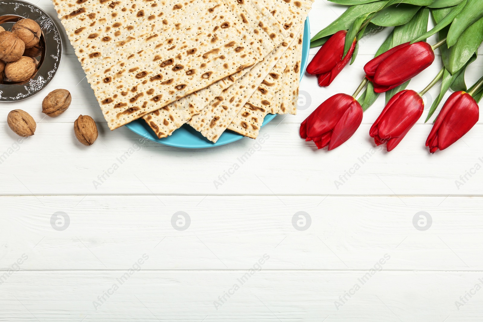 Photo of Flat lay composition with matzos on white wooden background, space for text. Passover (Pesach) celebration