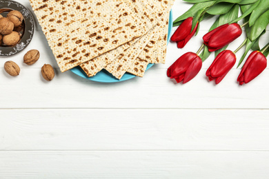 Photo of Flat lay composition with matzos on white wooden background, space for text. Passover (Pesach) celebration