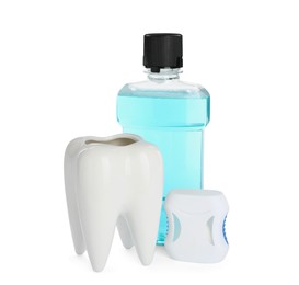 Photo of Tooth shaped holder, dental floss and mouthwash on white background
