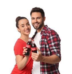 Photo of MYKOLAIV, UKRAINE - JANUARY 27, 2021: Young couple holding bottles of Coca-Cola on white background