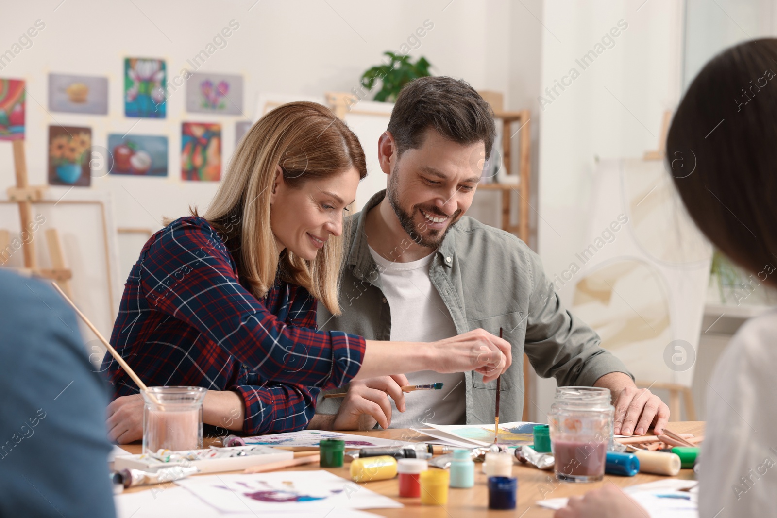 Photo of Group of students attending painting class in studio. Creative hobby