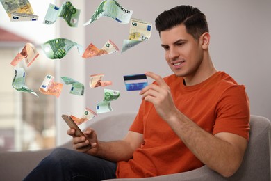 Online payment. Man with credit card buying something using mobile phone at home. Euro banknotes flying out of gadget as process of money transaction