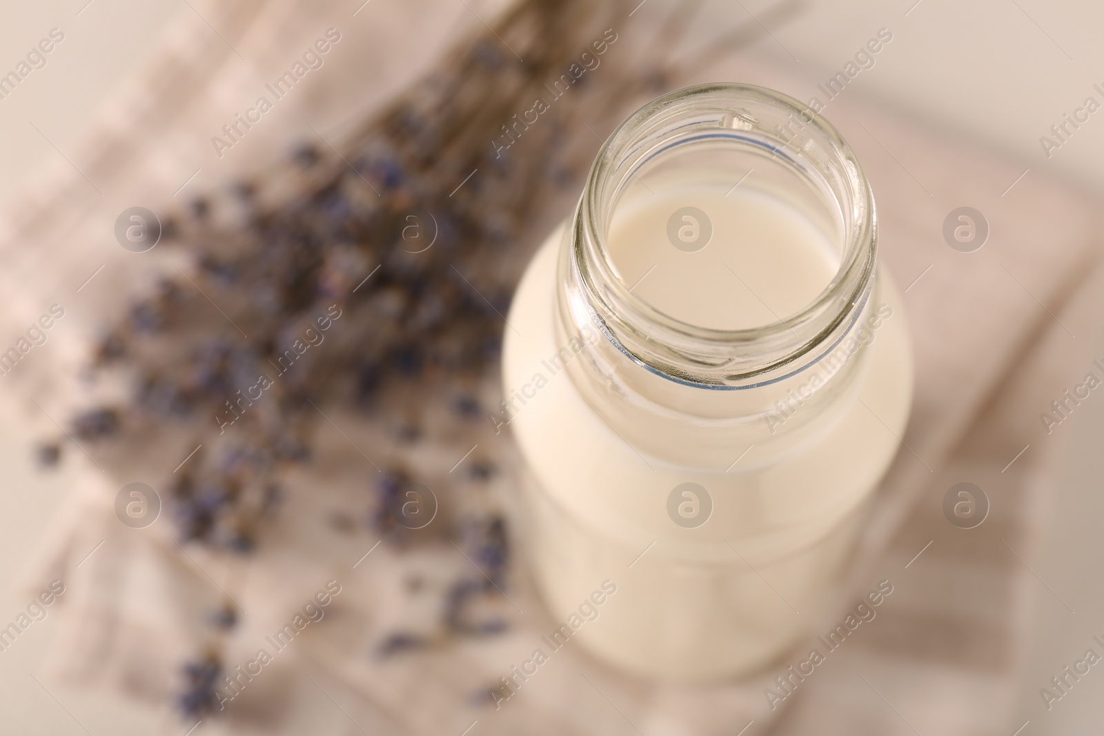Photo of Bottle of tasty milk on light table, above view. Space for text