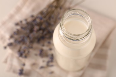 Bottle of tasty milk on light table, above view. Space for text