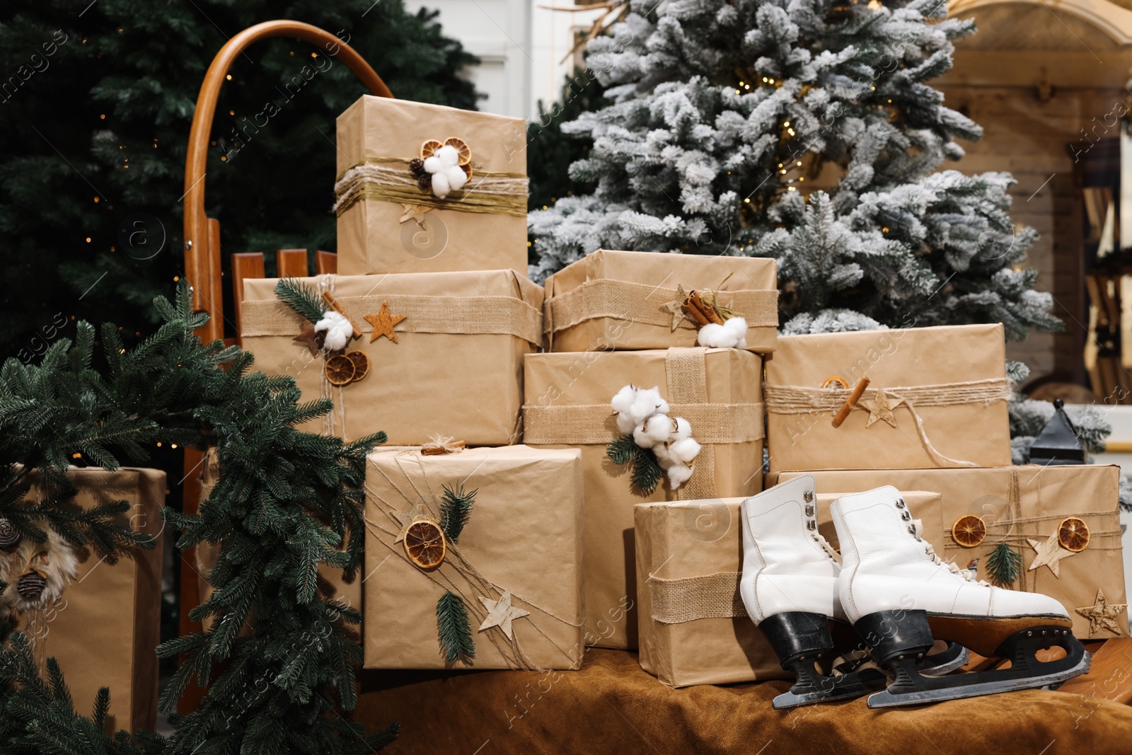 Photo of Many gift boxes, skates and festive decor indoors. Interior design