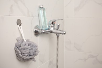 Photo of Grey shower puff and bottle of body wash gel in bathroom, space for text