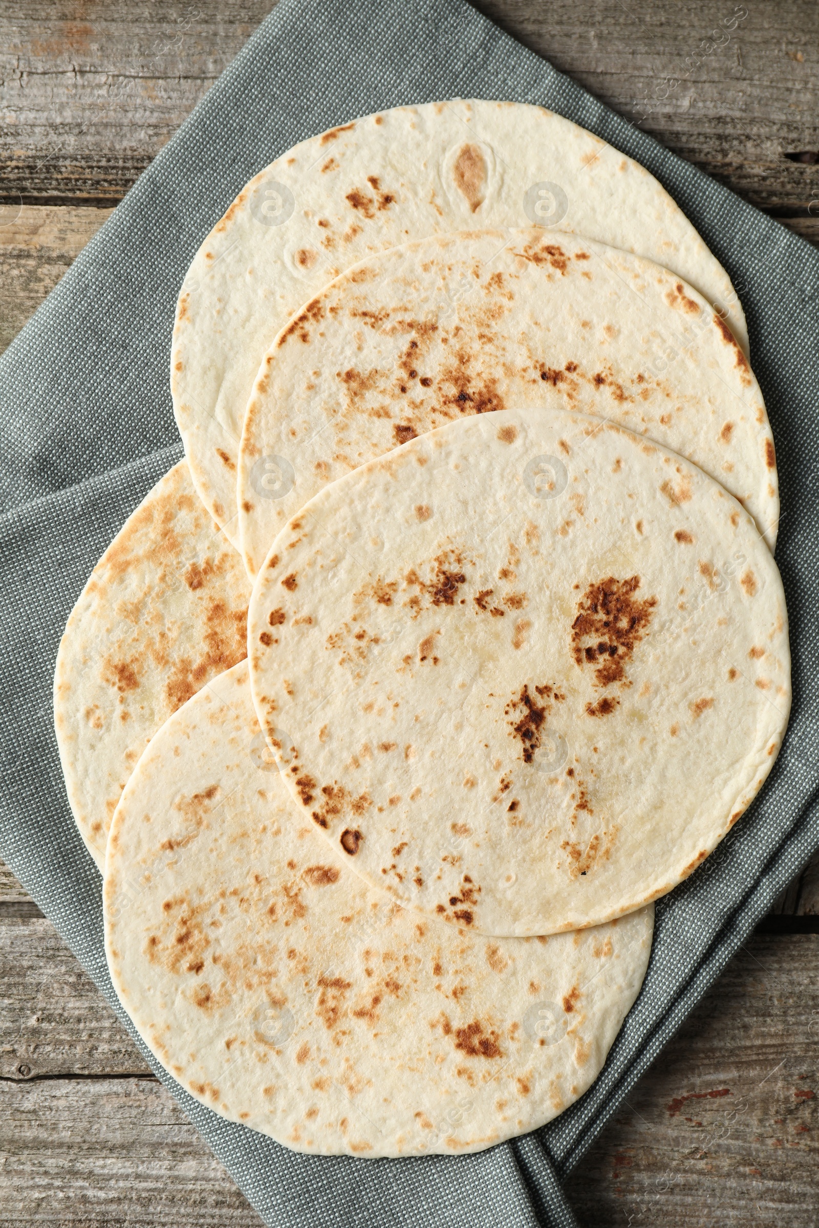Photo of Tasty homemade tortillas on wooden table, top view
