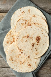 Photo of Tasty homemade tortillas on wooden table, top view