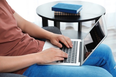 Man in casual clothes with laptop indoors