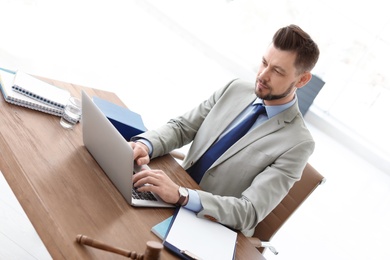 Photo of Male lawyer working with laptop in office