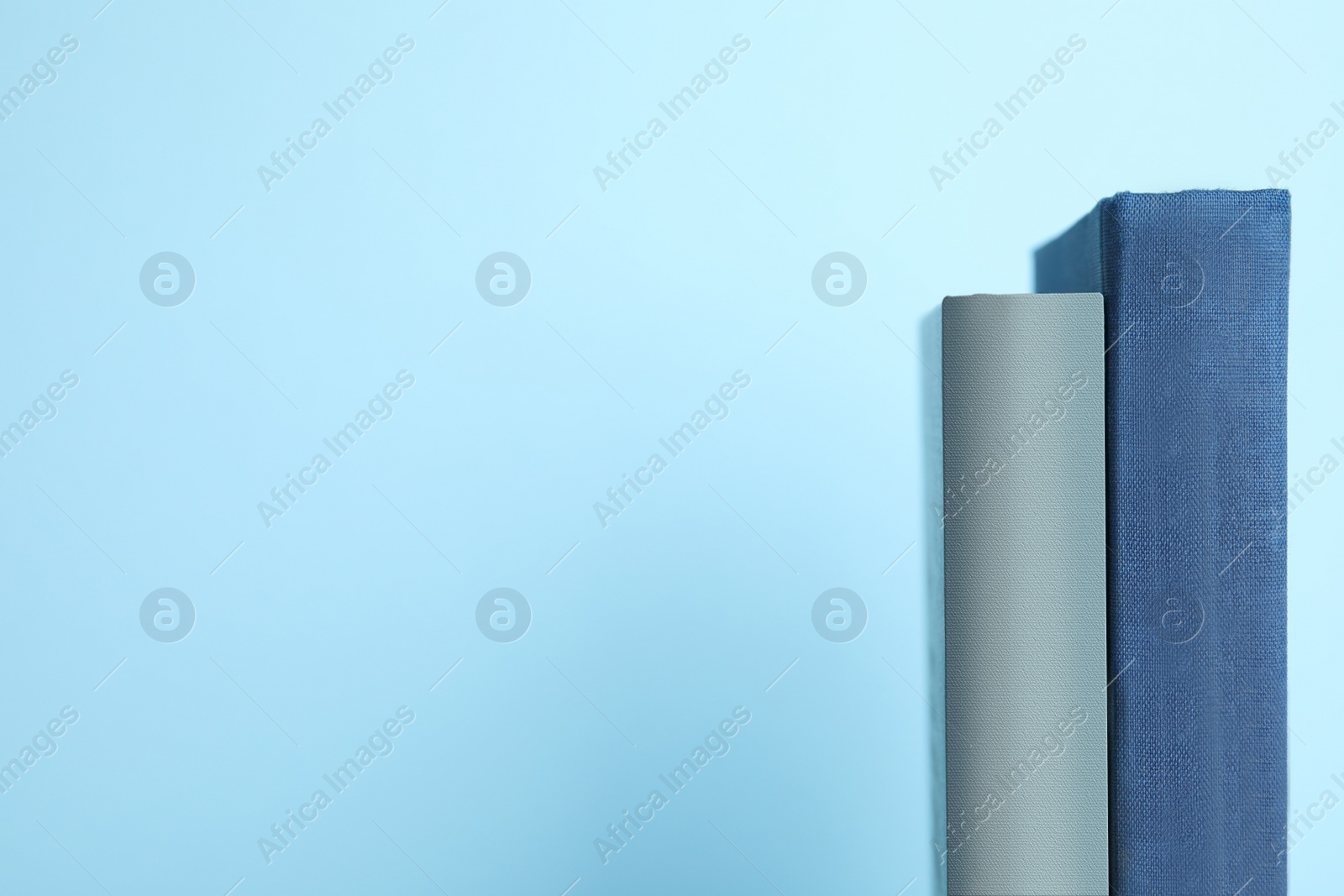 Photo of Old books on light blue background, space for text