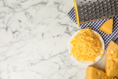 Flat lay composition with grated cheese on white marble table. Space for text