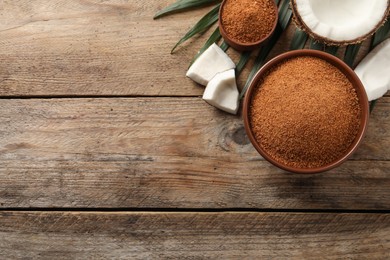 Flat lay composition with natural coconut sugar on wooden table, space for text